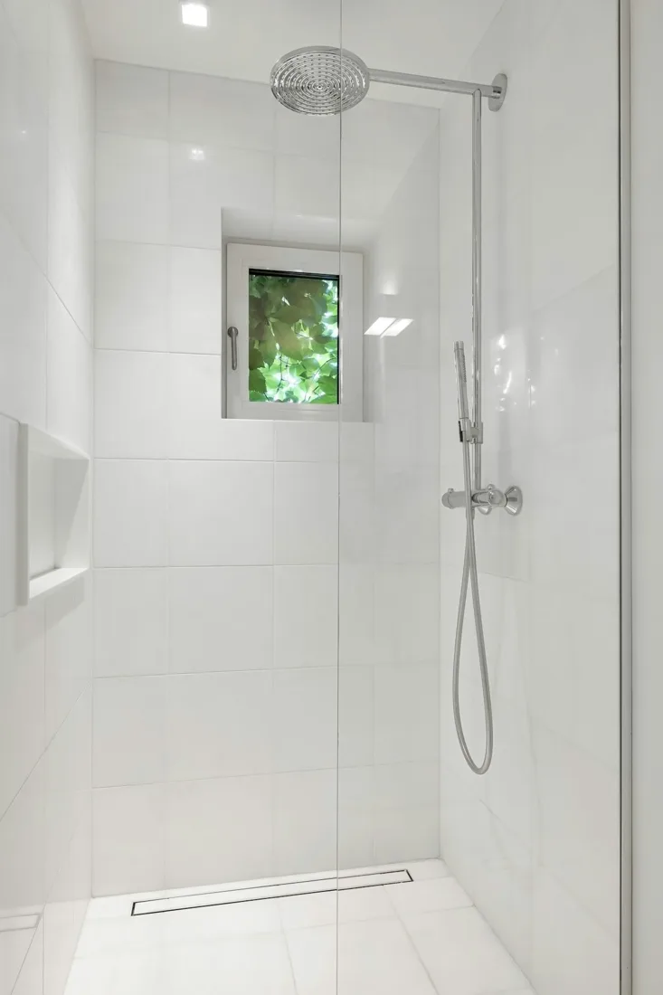Bathroom with a walk-in shower beside a window