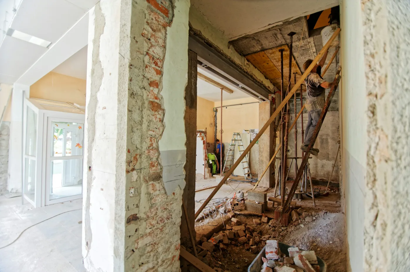 Interior renovation with exposed masonry, a wide opening, temporary supports and construction debris